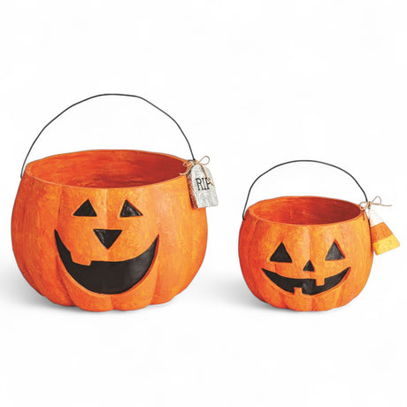 Two paper mache jack-o'-lantern treat buckets with wire handles and Halloween tags