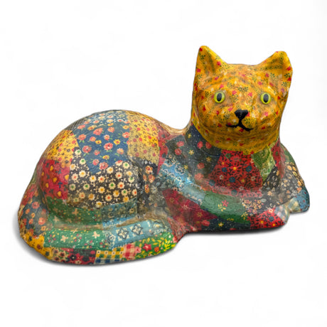 Colorful patchwork paper mache cat figurine with floral patterns and bright yellow eyes