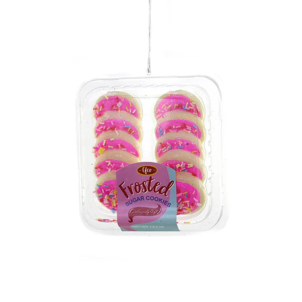 Pink frosted sugar cookies ornament with colorful sprinkles in clear tray
