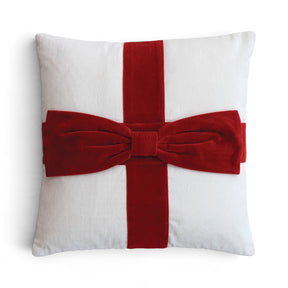 White square cotton velvet pillow with crossed red bands and an oversized dimensional red bow resembling a wrapped gift