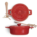 Red ceramic brie baker with side handles, an embossed matching lid, and a wooden spoon with a Christmas tree detail on the handle