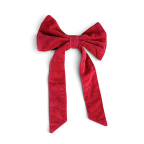 red cotton velvet Christmas bow with long angled tails and an attached black clip