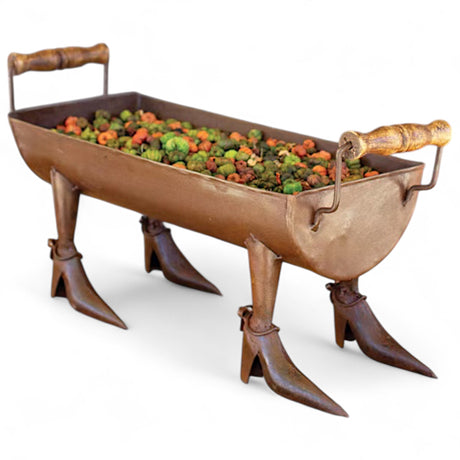 Rustic metal planter with witch boot legs and handles filled with fall decorative filler