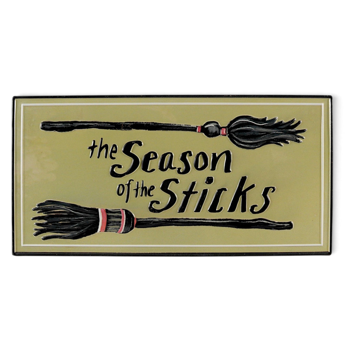 Embossed metal Halloween wall décor with witch brooms and The Season of the Sticks phrase