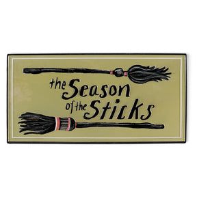 Embossed metal Halloween wall décor with witch brooms and The Season of the Sticks phrase