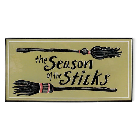 Embossed metal Halloween wall décor with witch brooms and The Season of the Sticks phrase