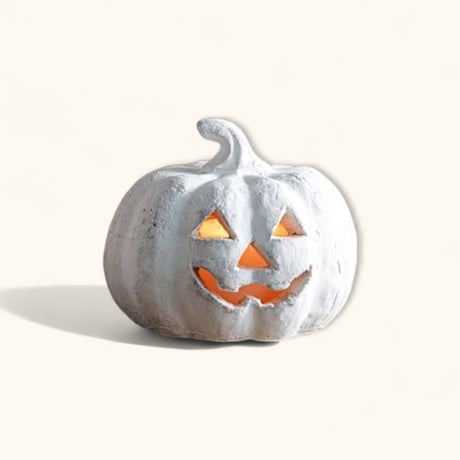 Small white terracotta jack-o’-lantern pumpkin with carved face and distressed finish