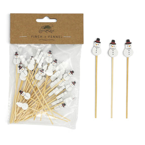 Packaged bamboo party picks beside three loose picks with white snowman handles, black top hats, and orange noses