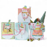 recycled paper gift bags with snowman designs and satin handles in assorted pastel winter colors.