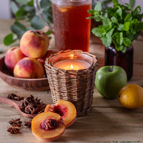 Southern Peach Tea candle with fresh peach fragrance and sweet tea scent in decorative woven willow candle vessel