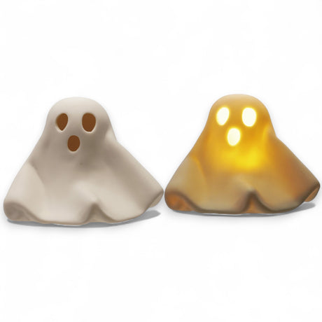 White stoneware ghost with LED light glowing through eyes