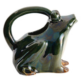 Stoneware frog-shaped watering can with reactive glaze in green, white, and brown tones.