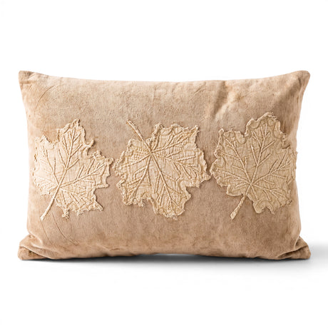 Tan velvet lumbar pillow with three dimensional embroidered leaf appliqués