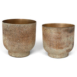 Two round metal planters with textured tarnished silver and bronze-toned surfaces, rounded bottoms, and short pedestal bases