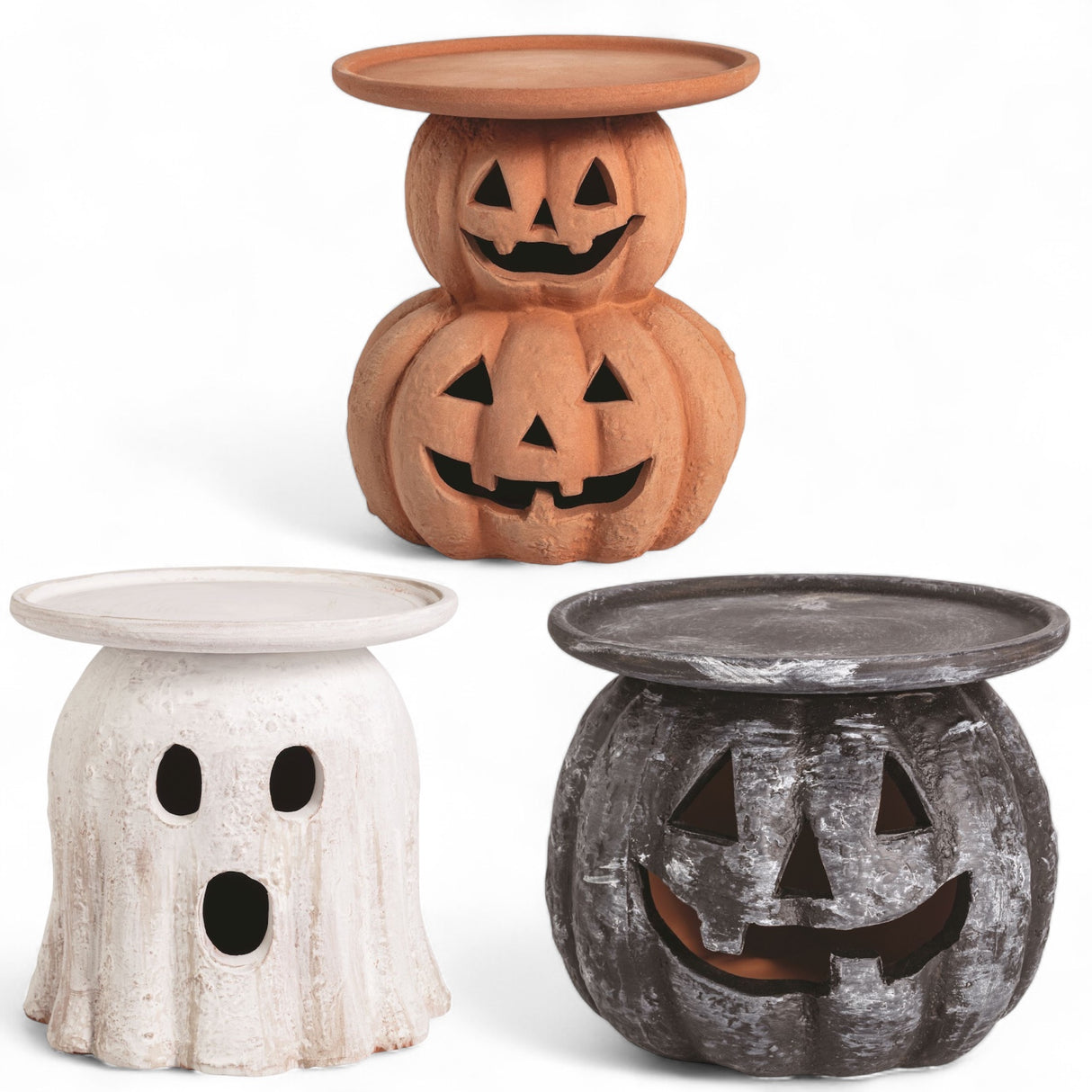 Three terracotta Halloween candle holders in pumpkin, ghost, and black jack-o'-lantern designs, each with a flat top for candles.
