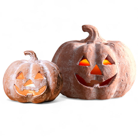 Terracotta jack-o’-lantern pumpkins in two sizes with carved faces and hollow interiors for candles