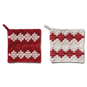 Two square woven cotton pot holders with tufted diamond patterns and hanging loops, one red with cream details and one cream with red details