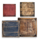 Assorted vintage hand-carved square wood trays with worn finish and natural grain