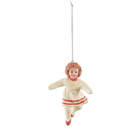 Vintage reproduction paper mache girl ornament with curly hair, a cream dress with red trim, red shoes, and a silver-colored hanging cord