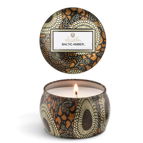 Voluspa Baltic Amber 4 oz Mini Tin Candle with decorative black, gold, and amber floral design
