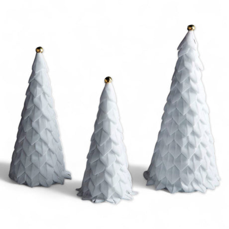White velvet holiday trees with ribbon loops and gold jingle bell toppers, available in three sizes