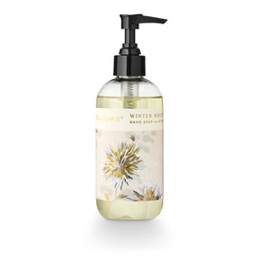 ILLUME Winter White hand soap in a clear 8 fl oz bottle with a black pump and cream botanical label with gold accents